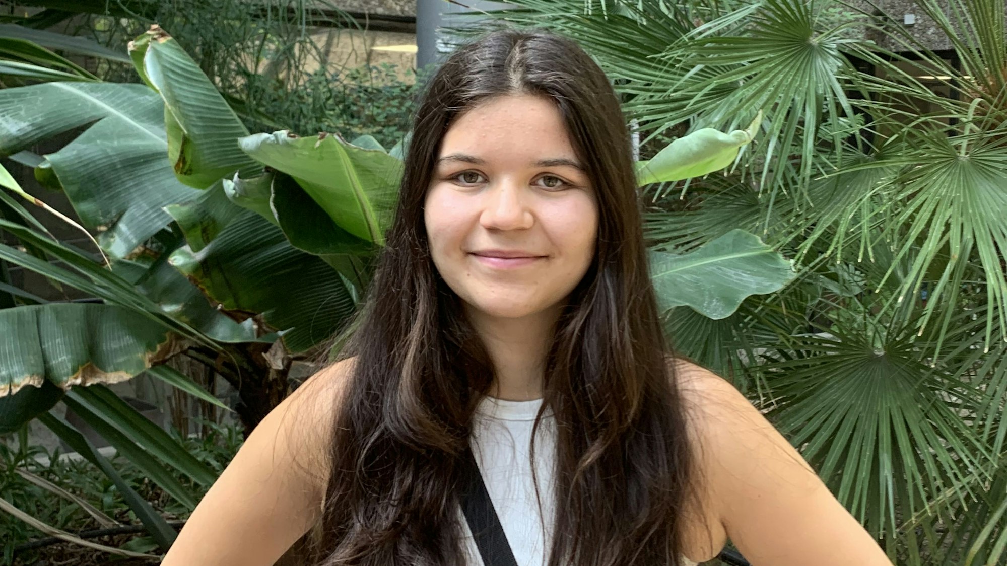 Das Porträtfoto zeigt Abiturientin Franziska Gies. Sie hat lange, dunkelbraune Haare und trägt ein weißes Top.