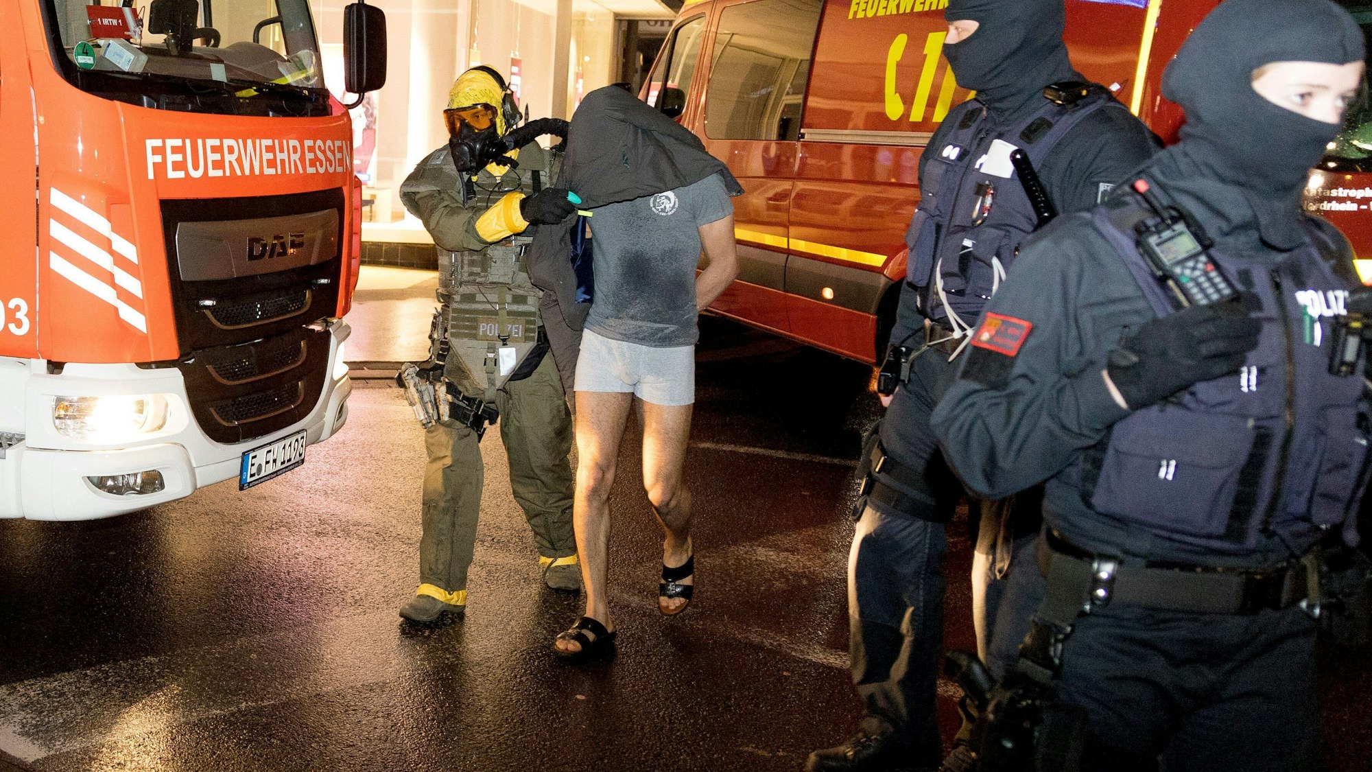 Castrop-Rauxel: Ein Mann wird von einem Beamten des Spezialeinsatzkommandos (SEK) mit Schutzmaske in Gewahrsam genommen.