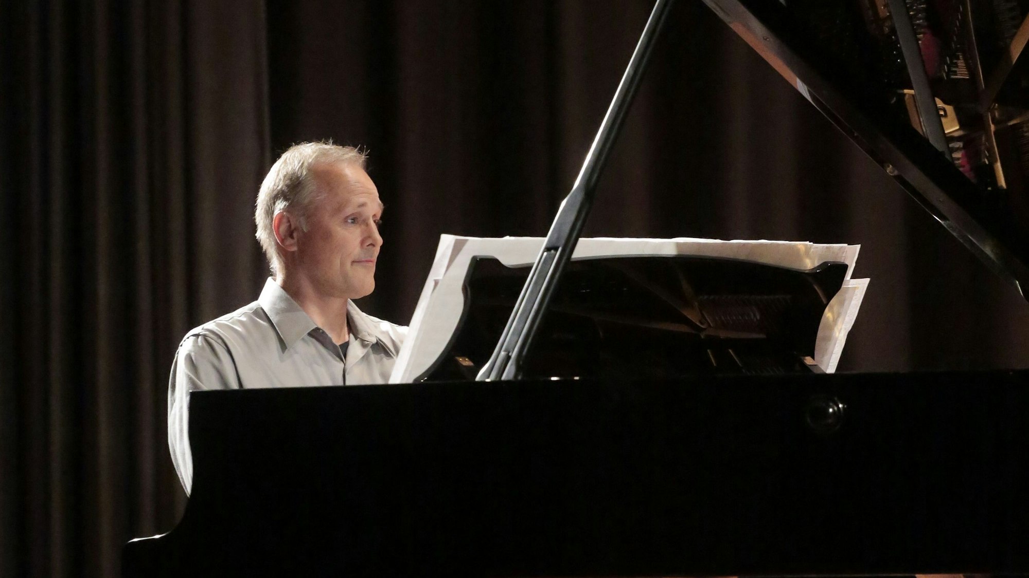 Der Mann sitzt am Flügel.