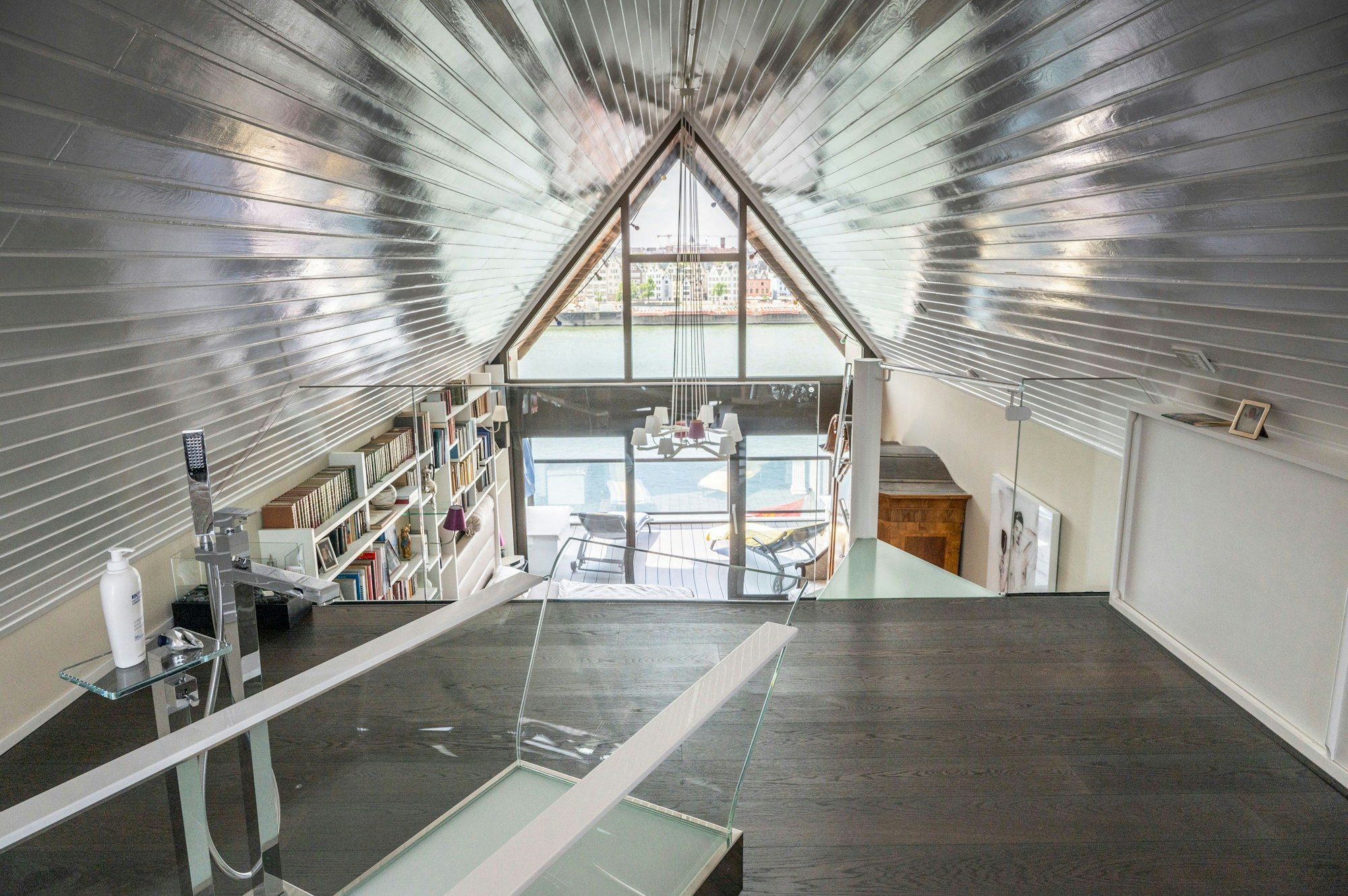 Auf der obersten Ebene unter dem Giebel steht eine gläserne Badewanne.