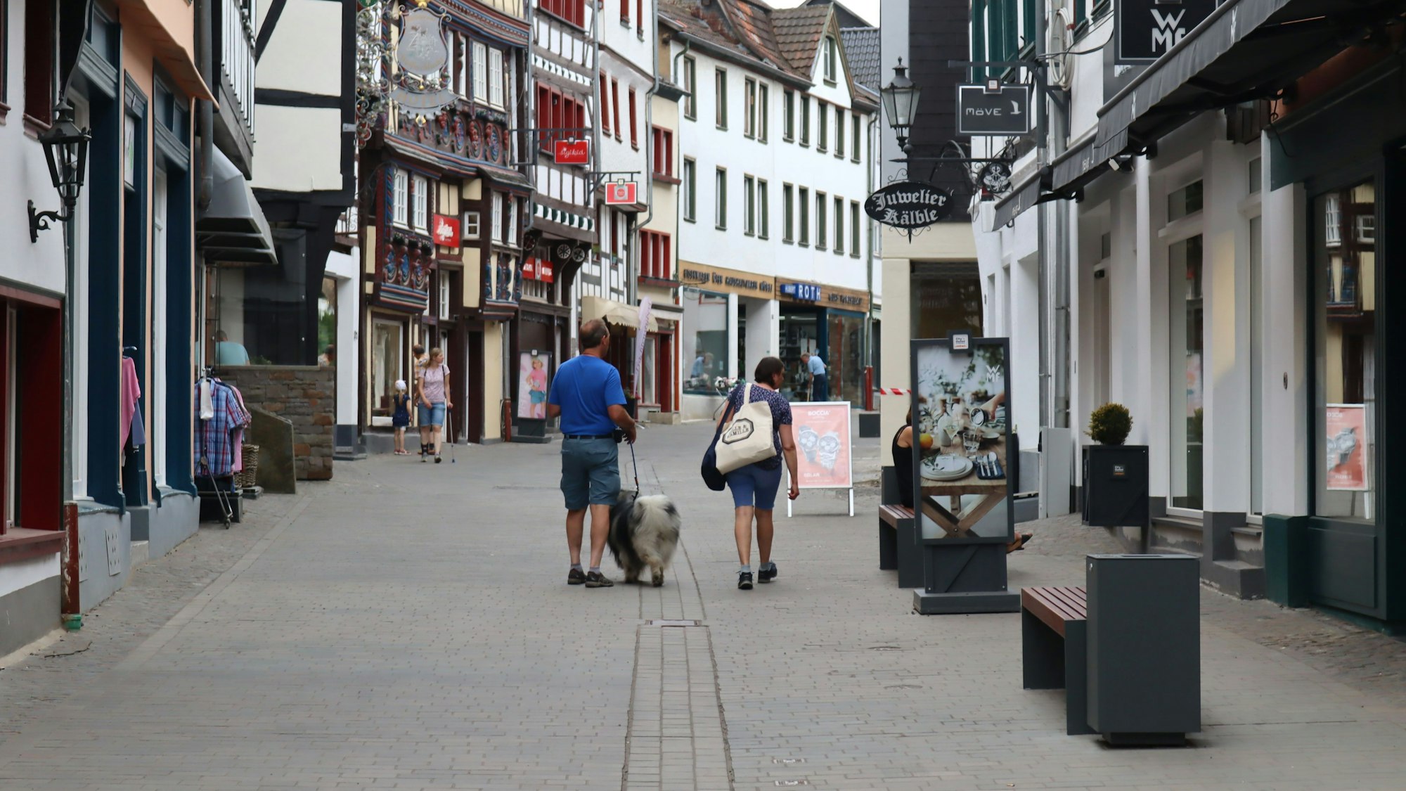 Ein Blick in die Orchheimer Straße, auf der Passanten an den Ladenlokalen entlanggehen.