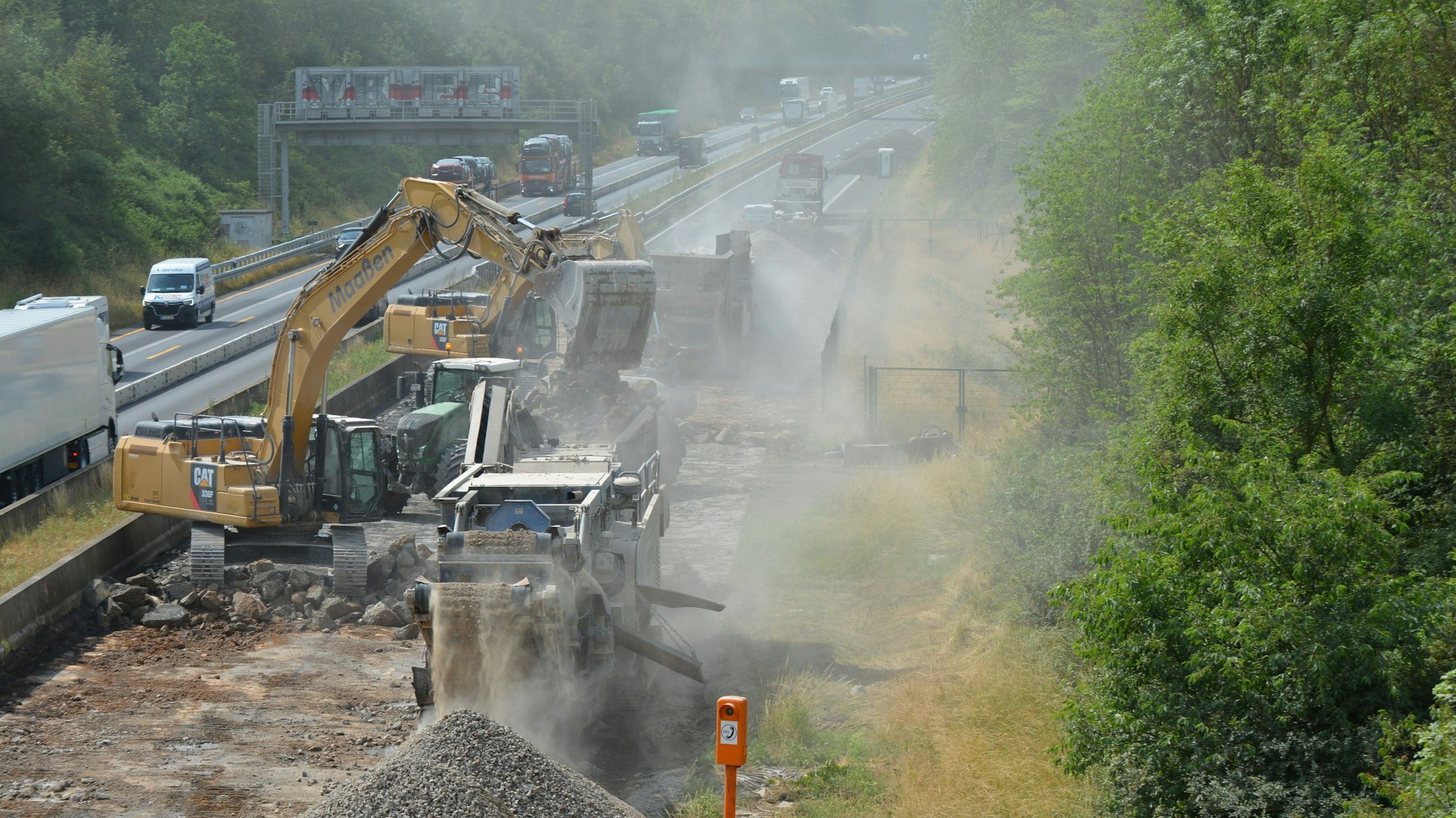 Auf dem Bild ist eine Baustelle mit Baggern und aufgerissener Fahrbahn auf der Autobahn A61 zu sehen.