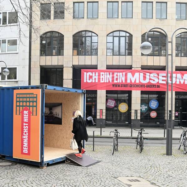 Das Bild zeigt das frühere Modehaus Sauer und einen Container davor.