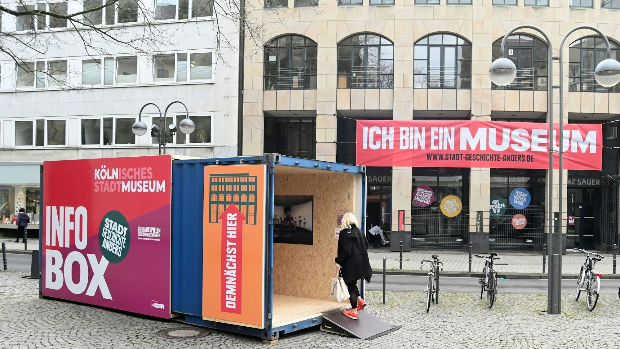 Das Bild zeigt das frühere Modehaus Sauer und einen Container davor.