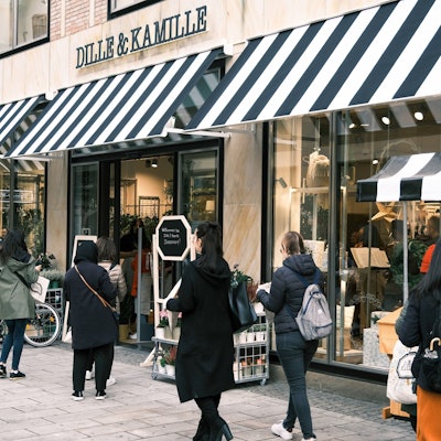 Kundinnen und Kunden stehen vor einer Filiale des Einrichtungshauses „Dille & Kamille“ in der Düsseldorfer Altstadt.