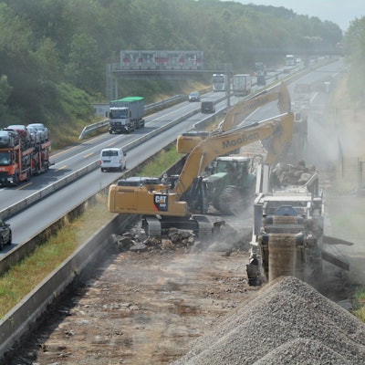 Baustellenfahrzeuge versperren die Fahrt auf der einen Richtung, der Verkehr weicht auf die andere Seite aus.