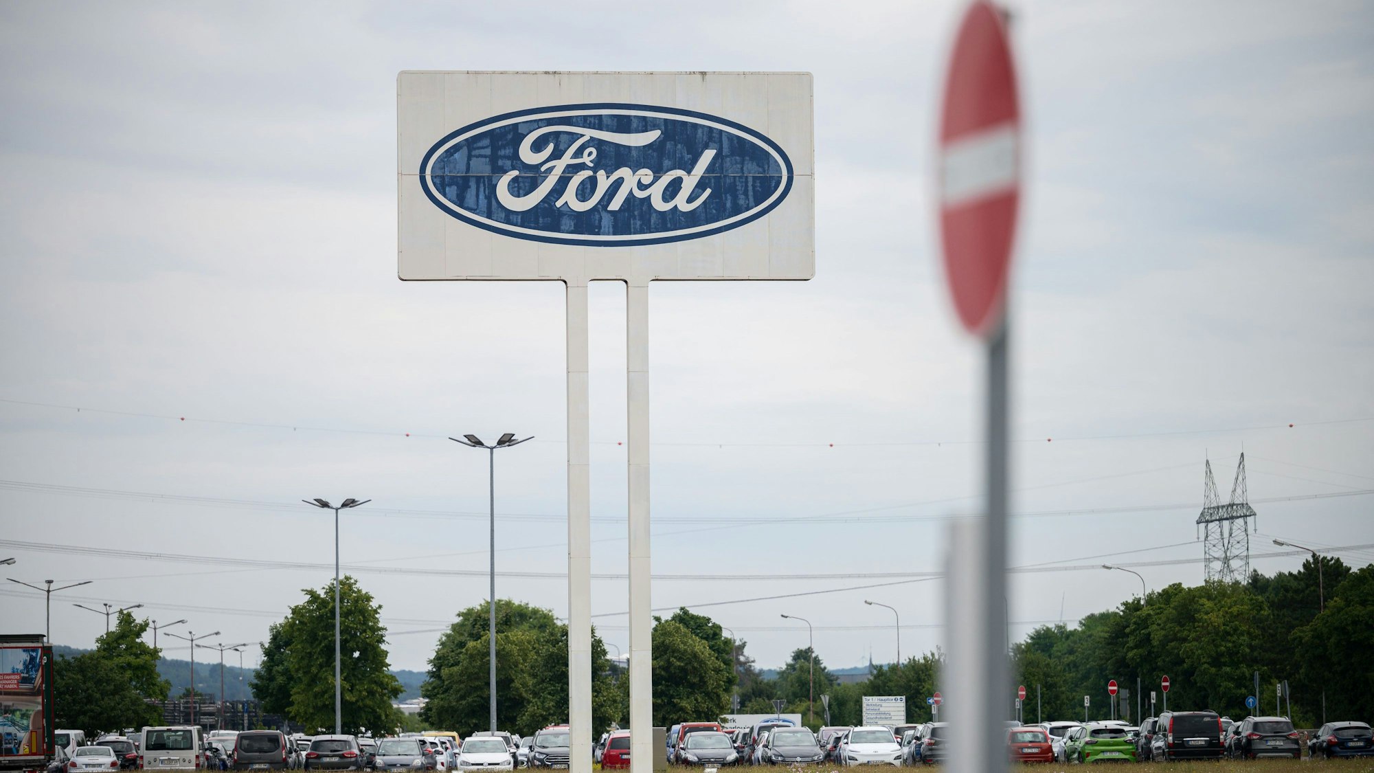 ARCHIV - 22.06.2022, Saarland, Saarlouis: Das große Logo von Ford, das auf dem Parkplatz des Werks Saarlouis steht, mit einem Durchfahrt Verboten Schild davor. (zu dpa: «IG Metall bereitet möglichen Arbeitskampf bei Ford vor») Foto: Oliver Dietze/dpa +++ dpa-Bildfunk +++