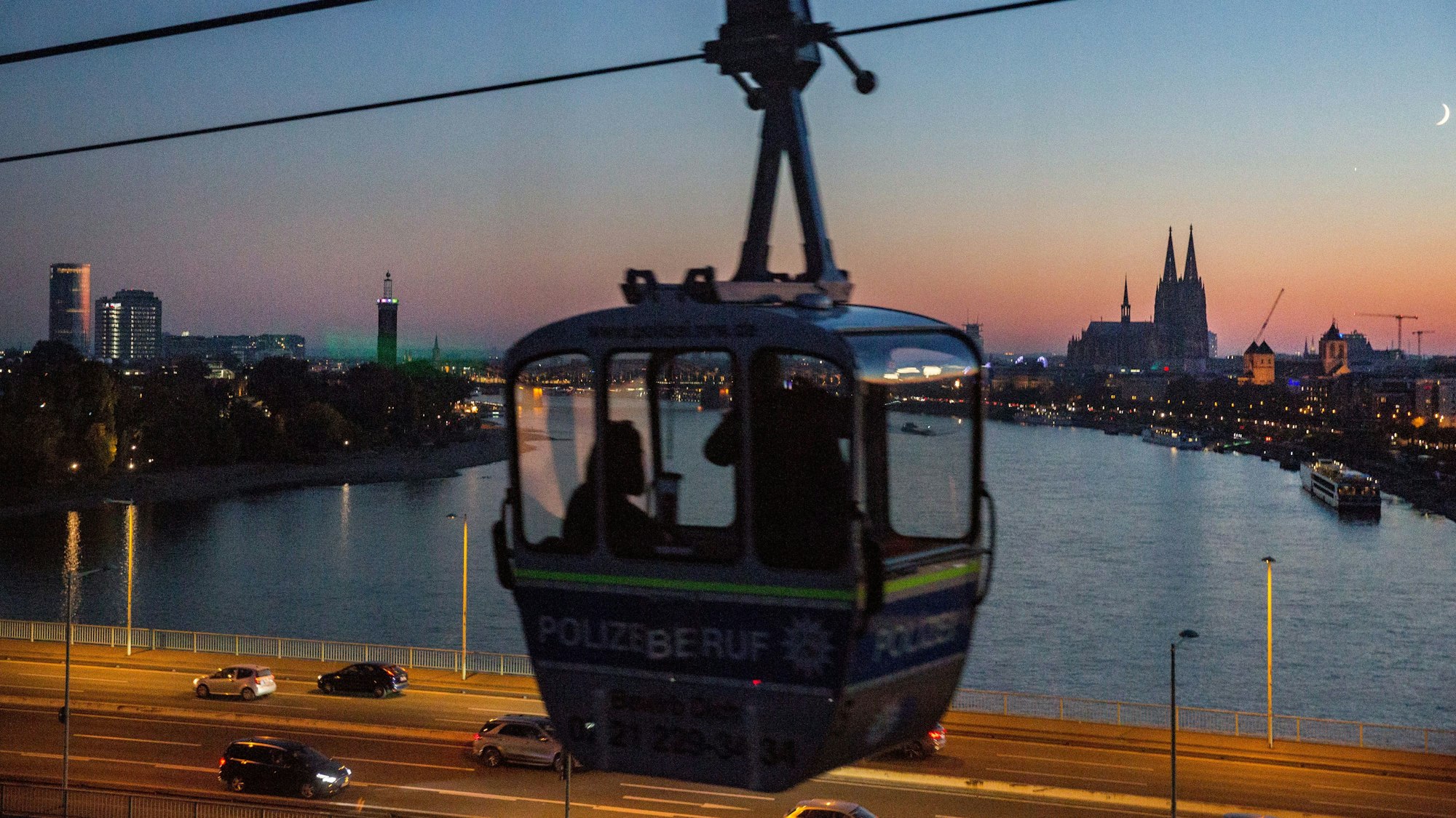 Foto aus der Herbstnachtfahrt der Kölner Seilbahn mit Blick auf Köln und die Zoobrücke.