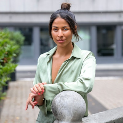 Negah Amiri lehnt an einem Brunnen.