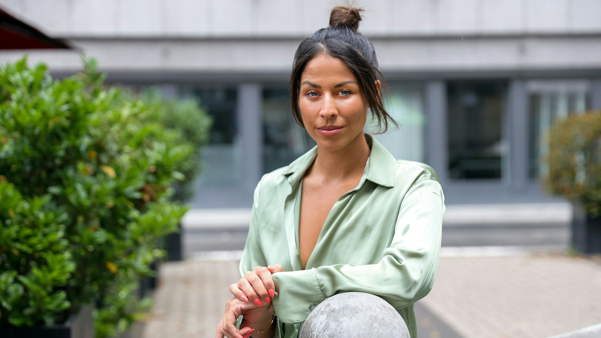 Negah Amiri lehnt an einem Brunnen.