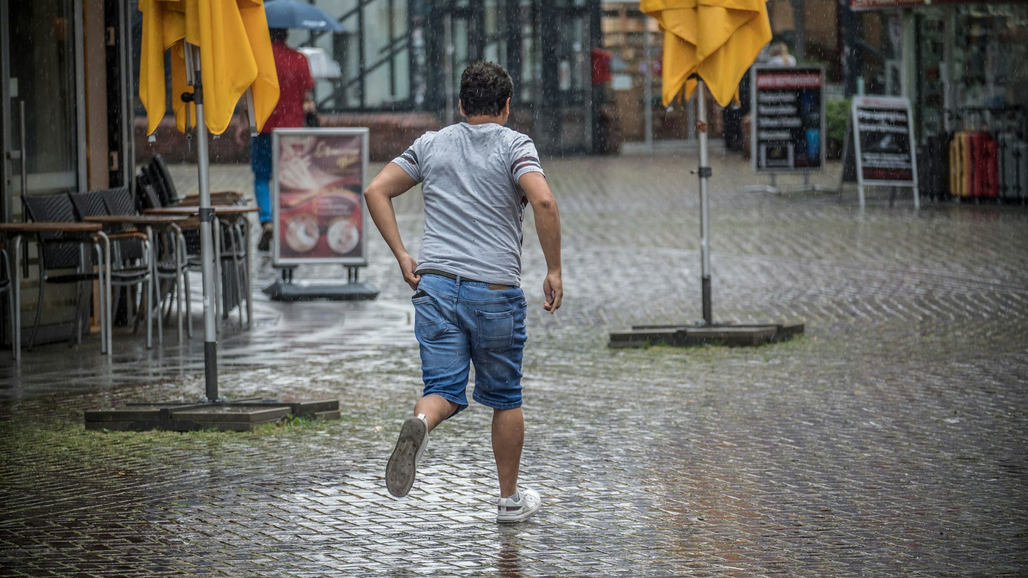 Ein Mann rennt im Regen.