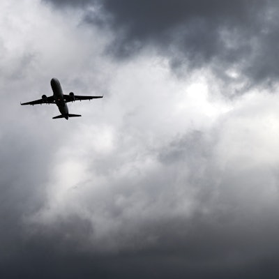 Über einem Flugzeug, das vom Flughafern Düsseldorf startet, türmen sich dunkle Wolken. (Archivbild)