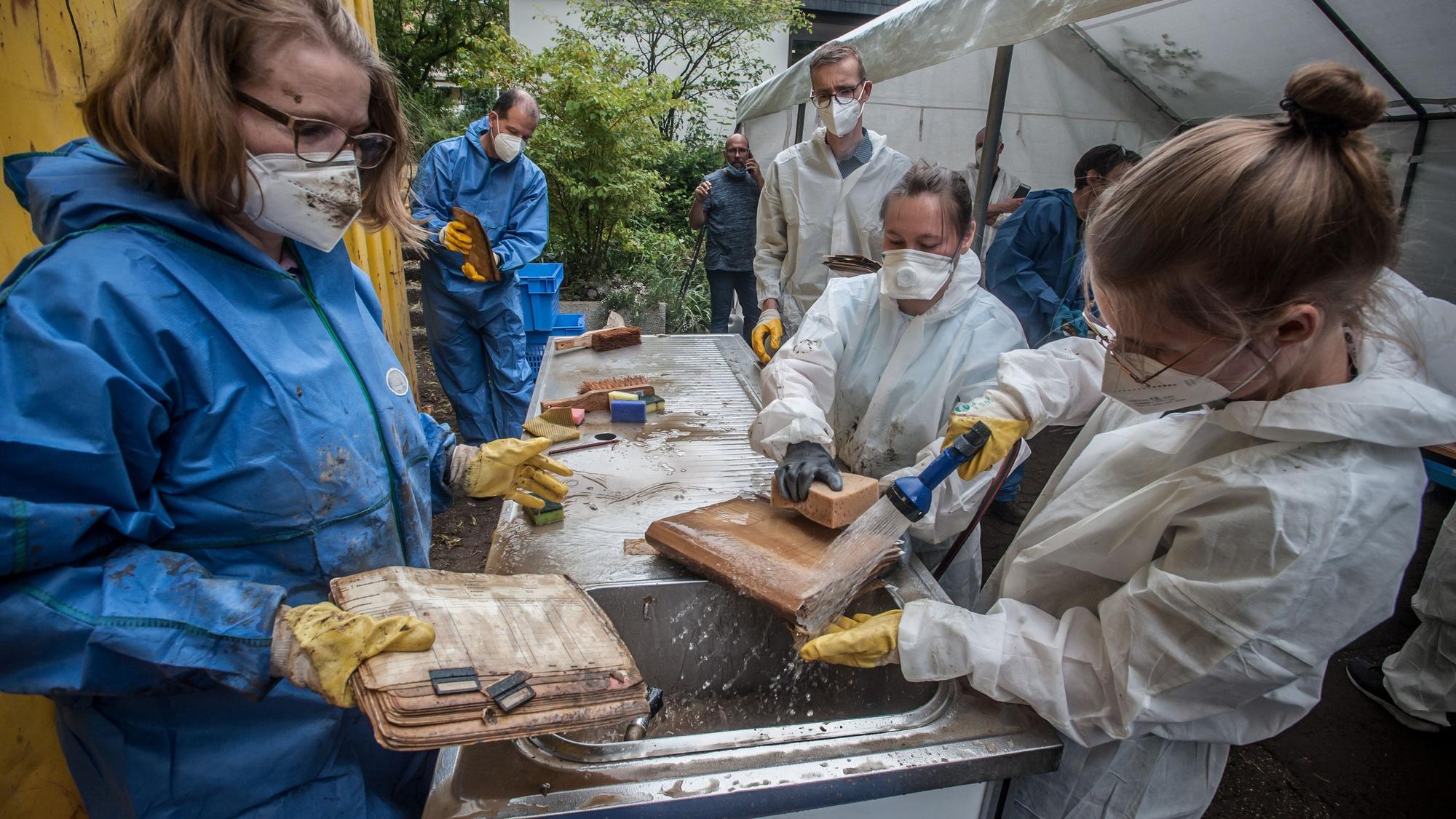 Nach dem Hochwasser: Stadtarchiv Leichlingen ist komplett überflutet gewesen. Akten und Pläne werden gewaschen, in Cellophan eingewickelt und zum Einfrieren abtransportiert.
