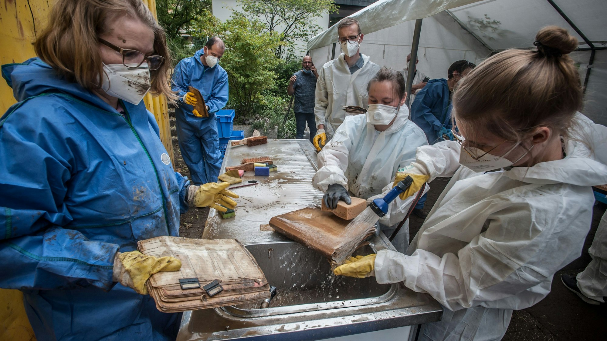 Nach dem Hochwasser: Stadtarchiv Leichlingen ist komplett überflutet gewesen. Akten und Pläne werden gewaschen, in Cellophan eingewickelt und zum Einfrieren abtransportiert.