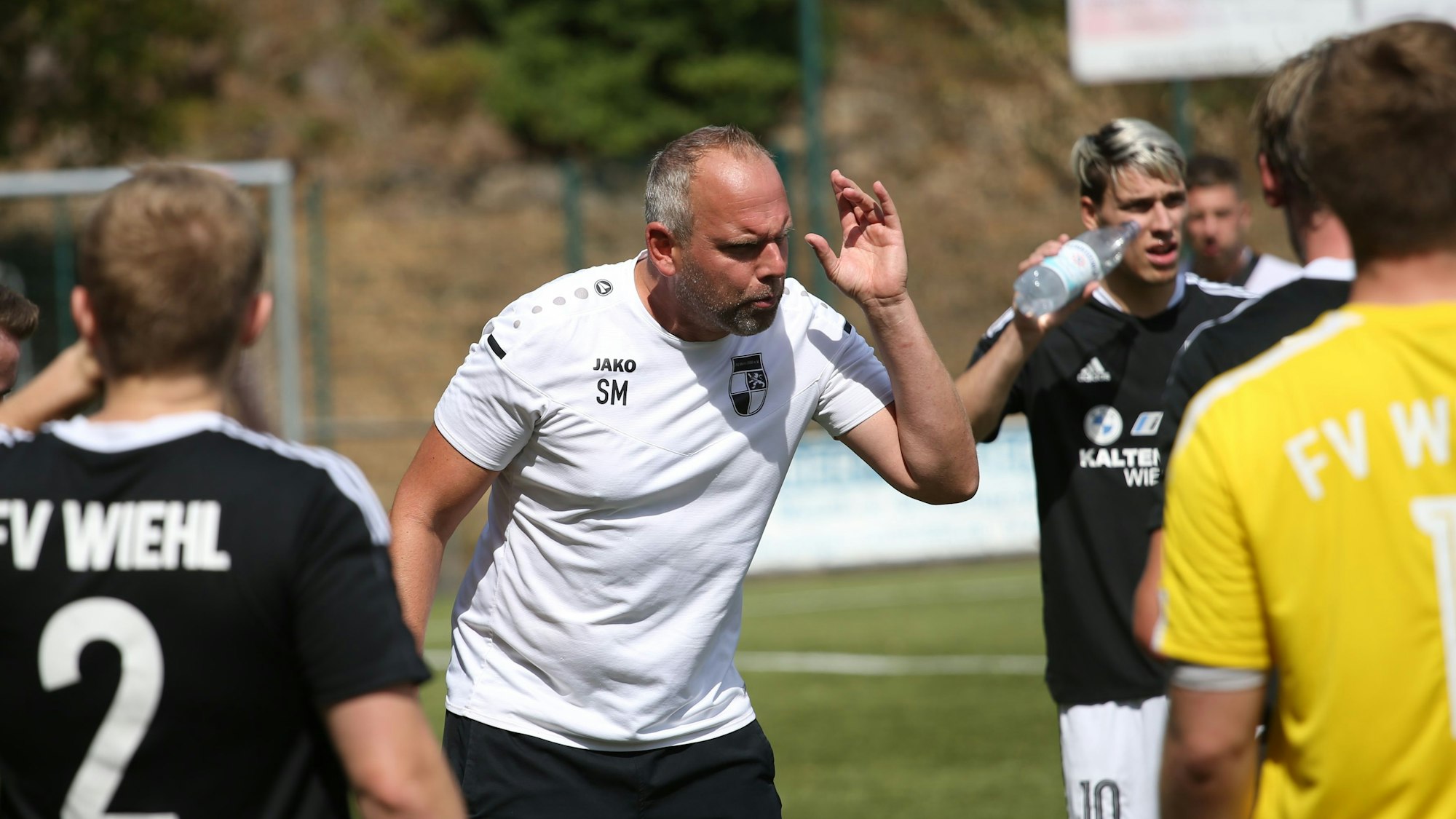 Ein Trainer gibt seinen Fußballspielern Anweisungen.