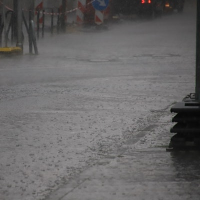 Ein Starkregen setzt eine Straße in Rhein-Sieg unter Wasser. Die Fahrbahn selbst ist kaum noch zu erkennen.