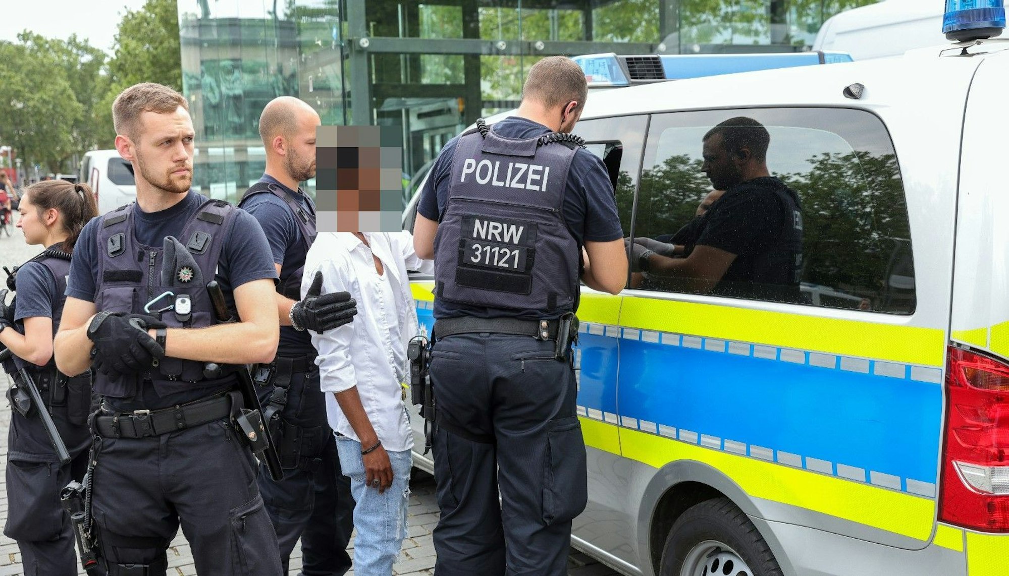 Polizisten nehmen ein Mann am Heumarkt fest und führen ihn in einen Polizeiwagen.