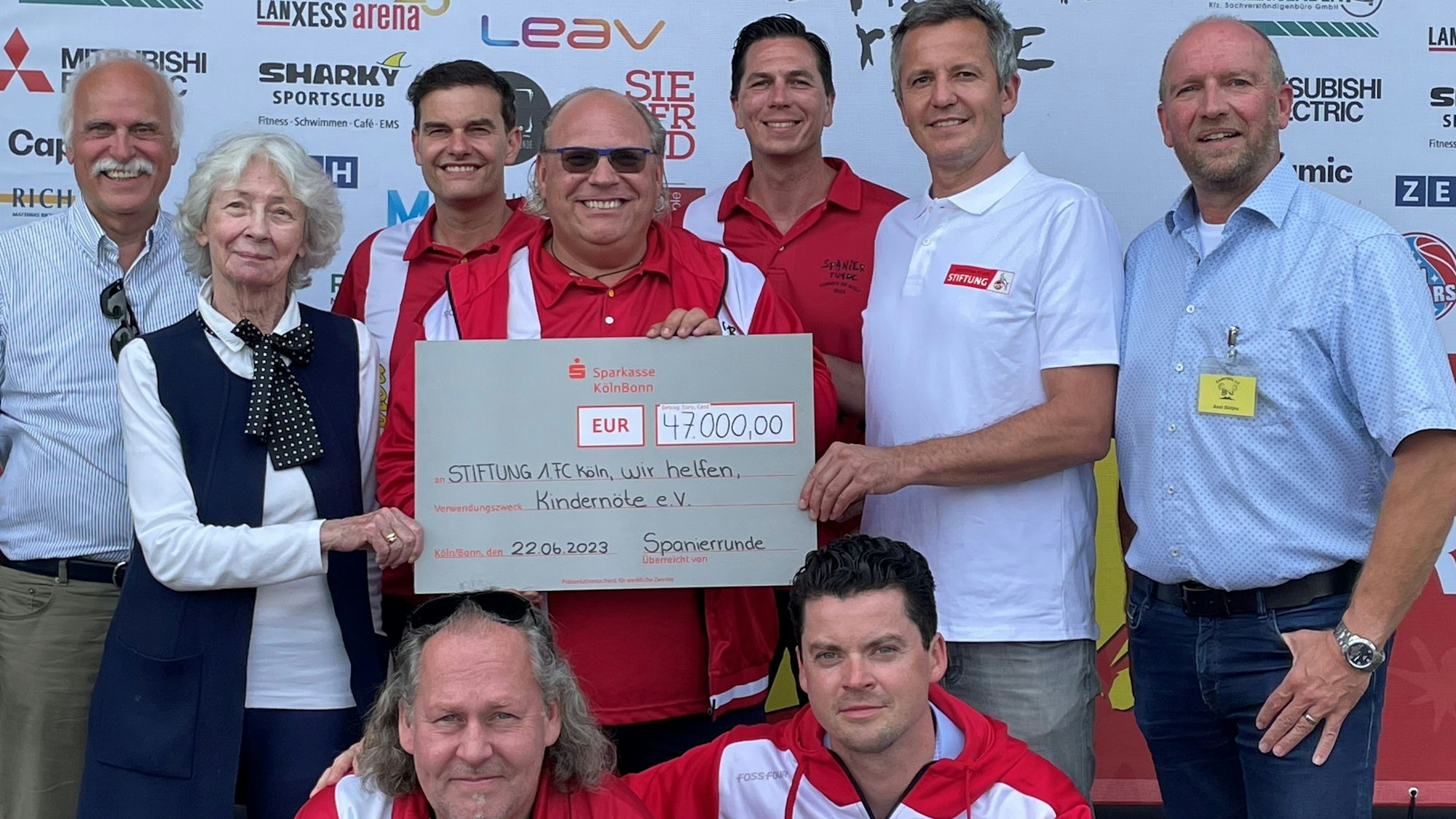 Spendenübergabe der Spanierrunde an Kölner Projekte für Kinder in Not mit (von links) Karl-Heinz Goßmann und Hedwig Neven DuMont („wir helfen“), Marco Pütz (MLS), Oliver Dillenburger, Marco Kersting (Mitsubishi Electric), Philipp Türoff (1.FC Köln), Axel Rütjes („Kindernöte“), Stefan Gottschalk (Gotti GmbH) und Christian Kruse (Kruse Immobilien)