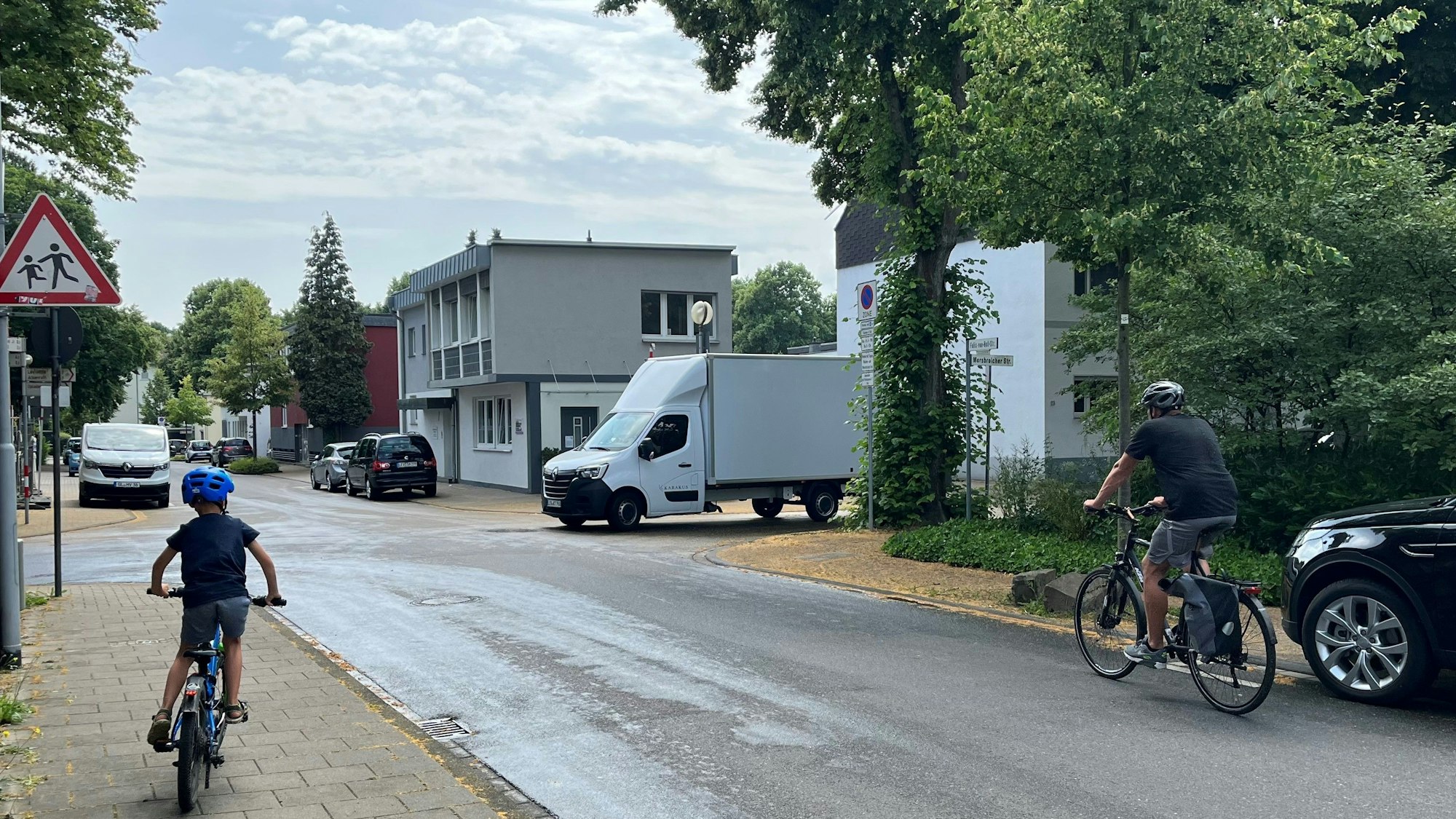 Kind fährt auf Gehweg, Transporter auf der Straße