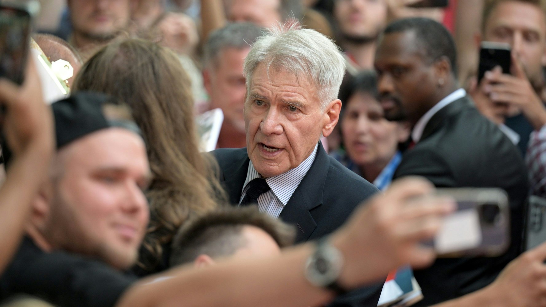 Harrison Ford (M) kommt zu der Deutschlandpremiere des Films „Indiana Jones und das Rad des Schicksals“ im Zoo Palast in Berlin.
