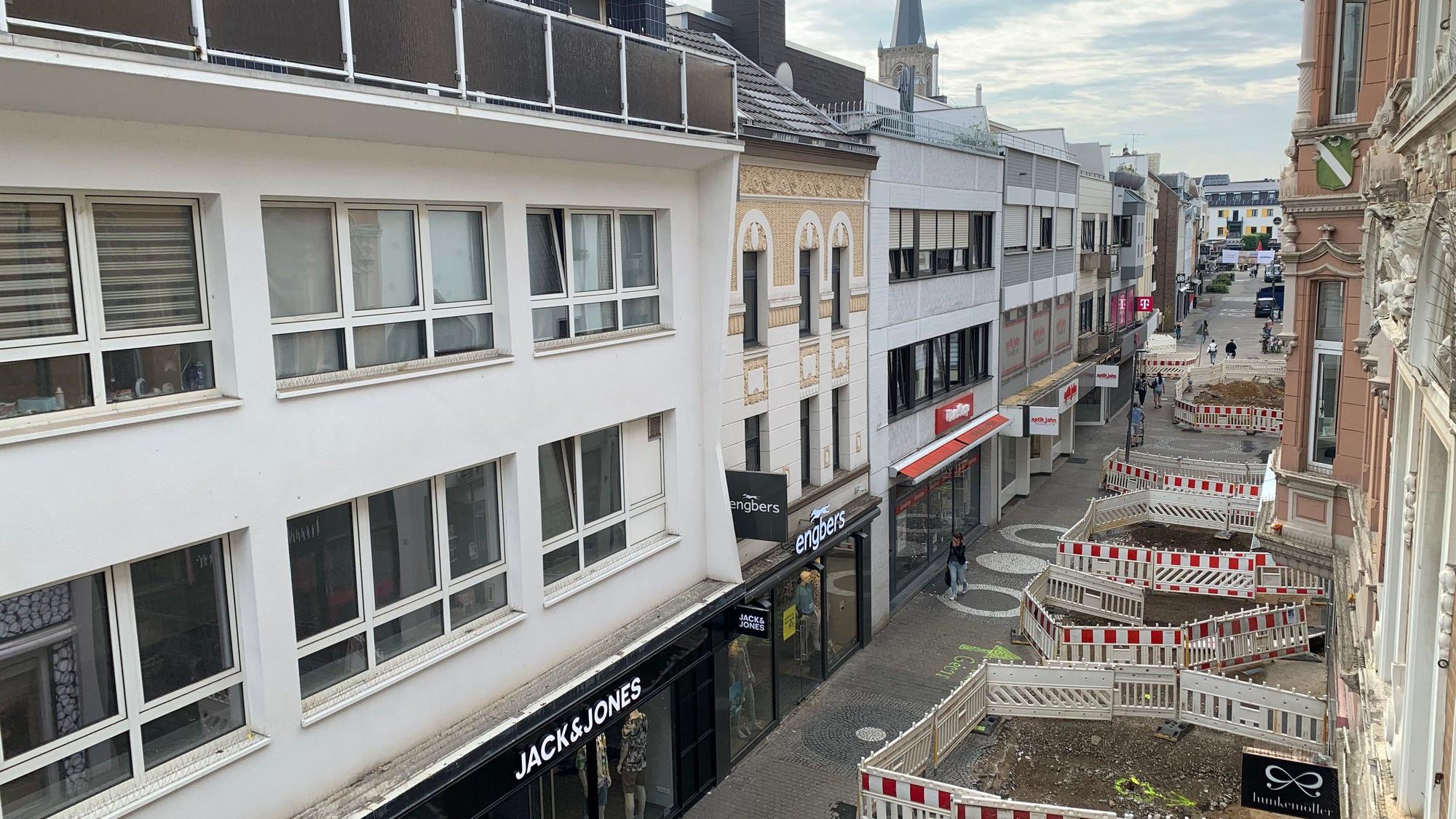 Teile der Straße sind mit Bauzäunen abgesperrt. Für die Passanten bleiben nur enge Wege.