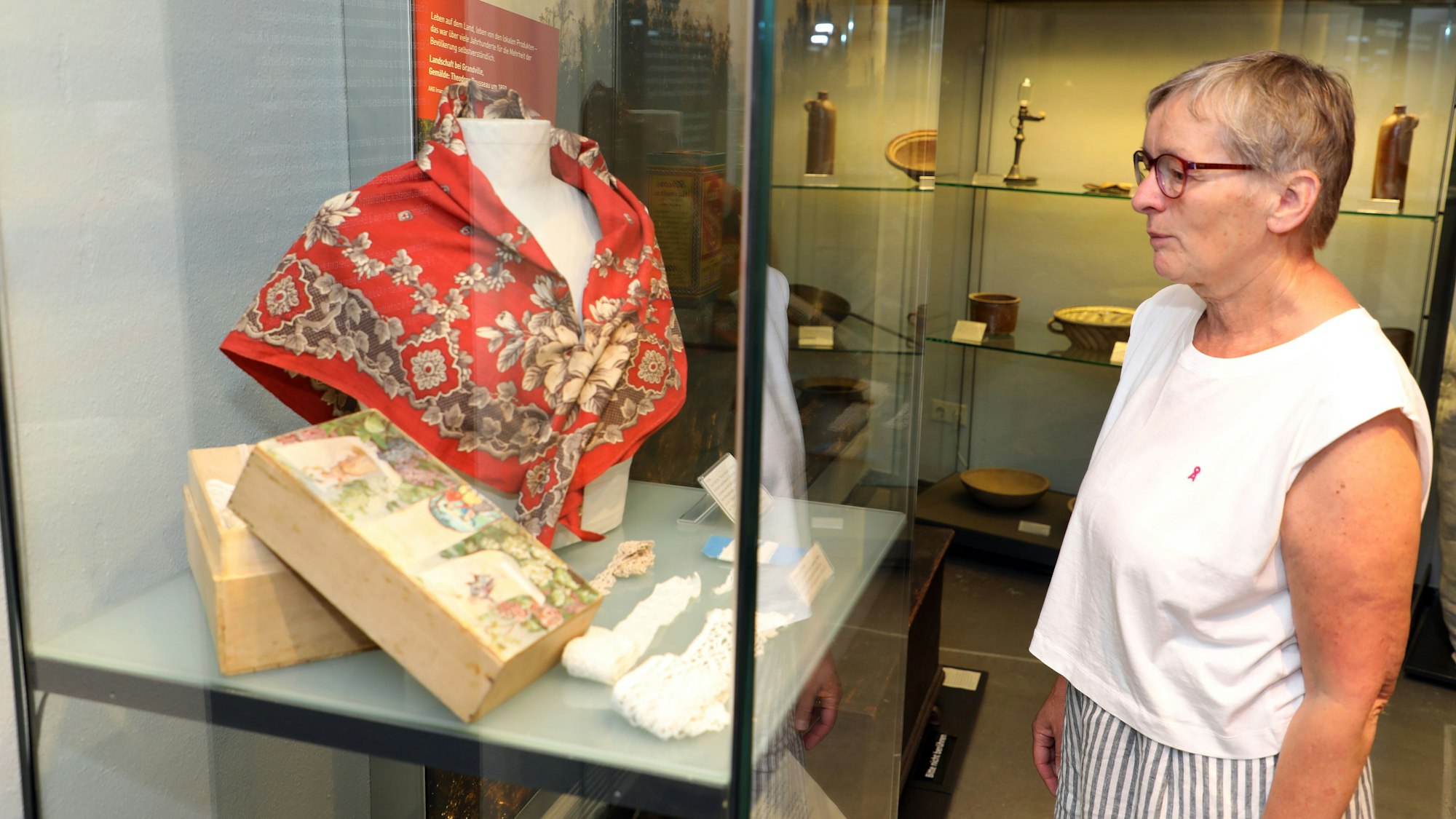 Beatrix Commandeur vor einer Vitrine in der Ausstellung „Must Have“