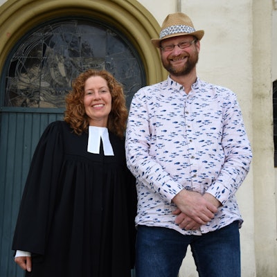 Es sind die beiden Personen vor der Kirche zu sehen.