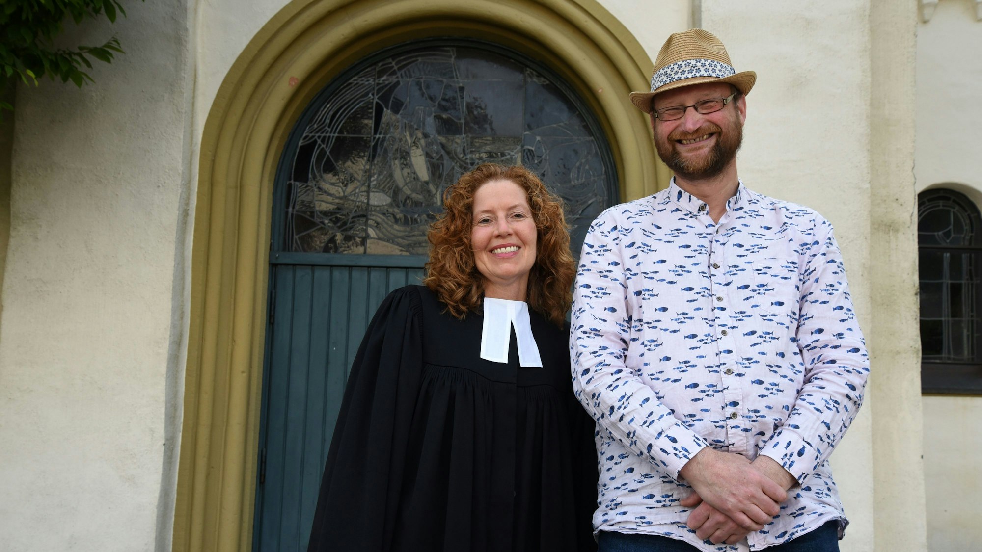 Es sind die beiden Personen vor der Kirche zu sehen.