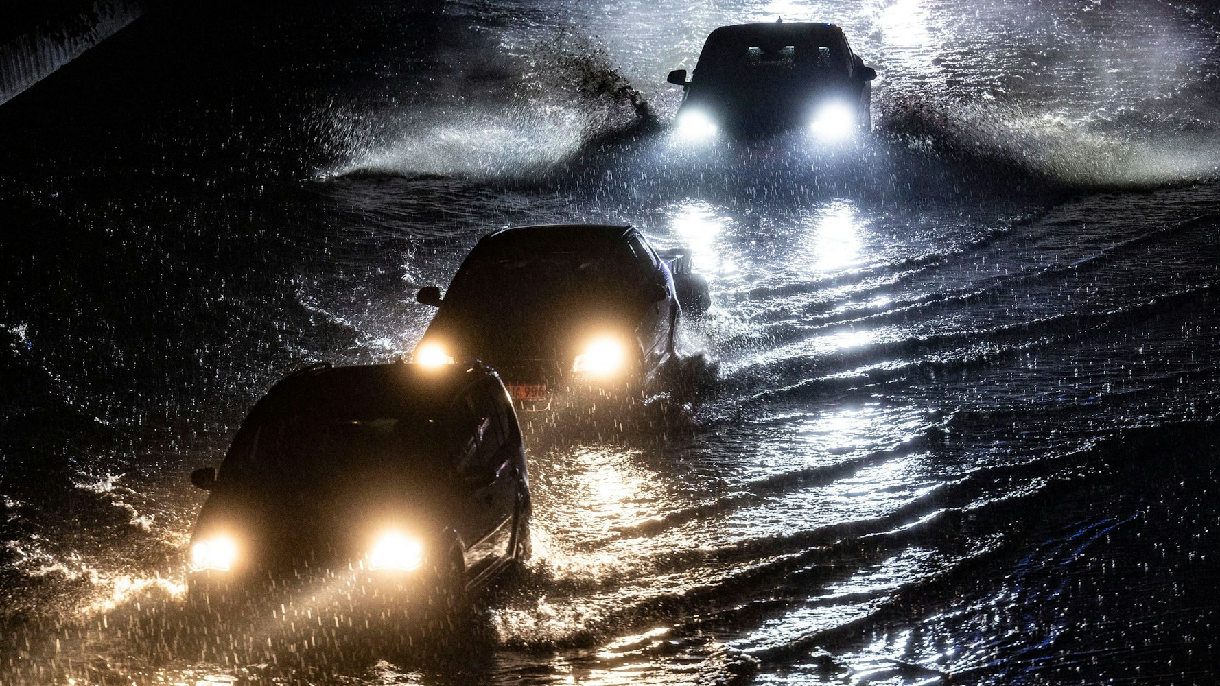 22.06.2023, Duisburg: Teilabschnitte der Autobahn A59 in Duisburg sins am Abend nach stundenlangen Regenfällen überschwemmt, Autos fahren durch die Wassermassen. Mit teils heftigen Regenfällen und Gewittern hat ein Unwetter Nordrhein-Westfalen am Donnerstag erreicht. Für weite Teile des bevölkerungsreichsten Bundeslandes gab der Deutsche Wetterdienst (DWD) Unwetterwarnungen heraus. Foto: Christoph Reichwein/dpa +++ dpa-Bildfunk +++