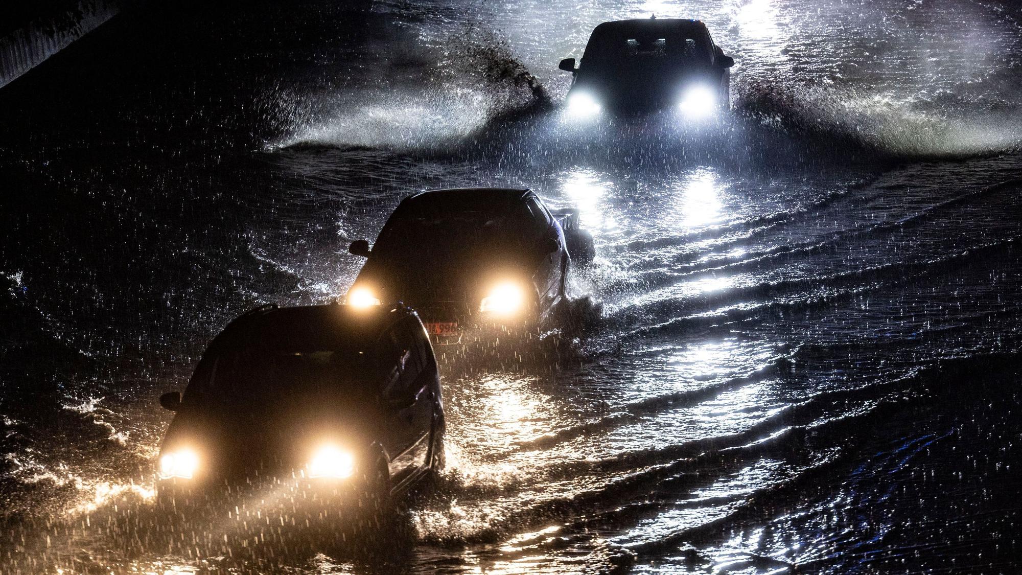 22.06.2023, Duisburg: Teilabschnitte der Autobahn A59 in Duisburg sins am Abend nach stundenlangen Regenfällen überschwemmt, Autos fahren durch die Wassermassen. Mit teils heftigen Regenfällen und Gewittern hat ein Unwetter Nordrhein-Westfalen am Donnerstag erreicht. Für weite Teile des bevölkerungsreichsten Bundeslandes gab der Deutsche Wetterdienst (DWD) Unwetterwarnungen heraus. Foto: Christoph Reichwein/dpa +++ dpa-Bildfunk +++