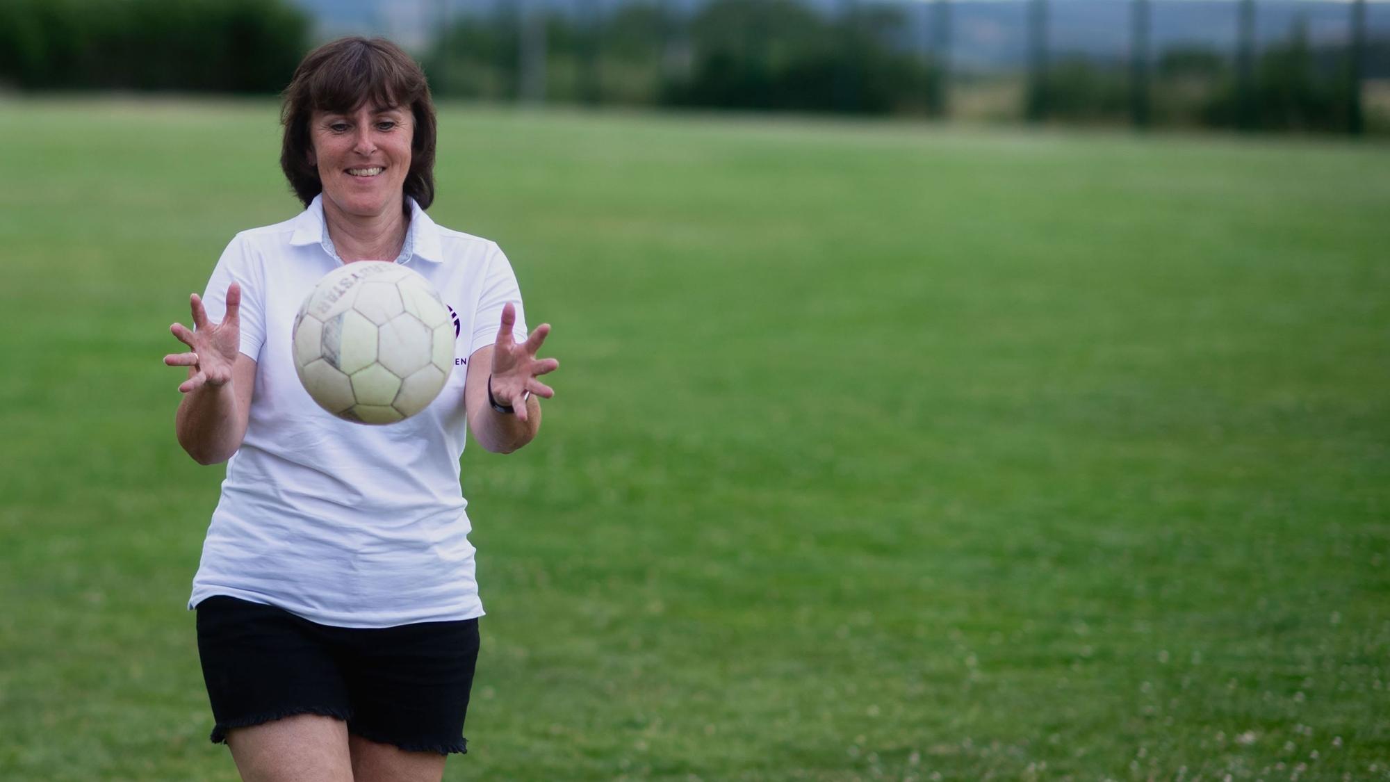 Die Vorsitzende des Fußballkreises Euskirchen, Doris Mager, fängt einen Ball.