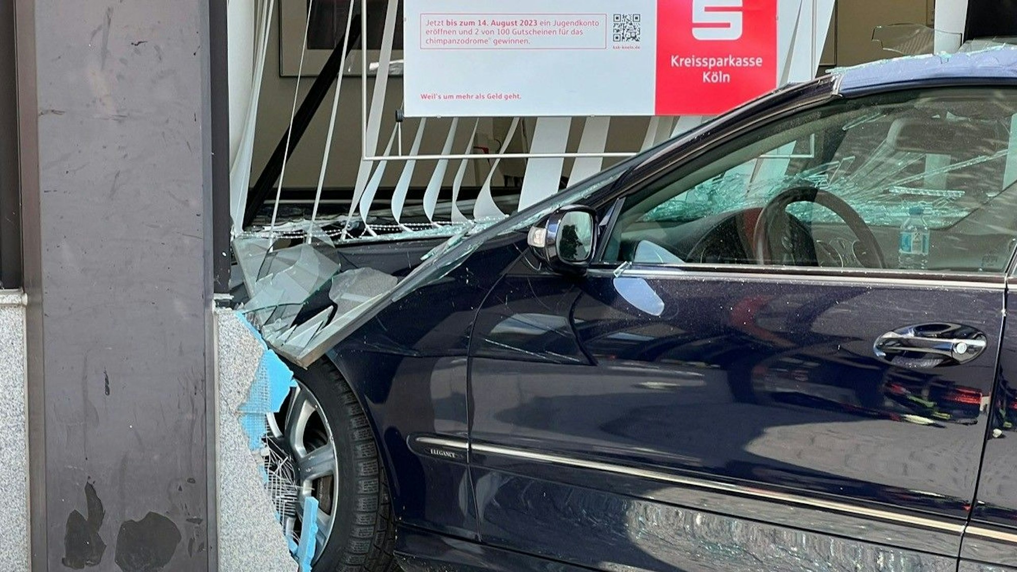 Ein Auto steht mit der Front im Gebäude der Bankfiliale.