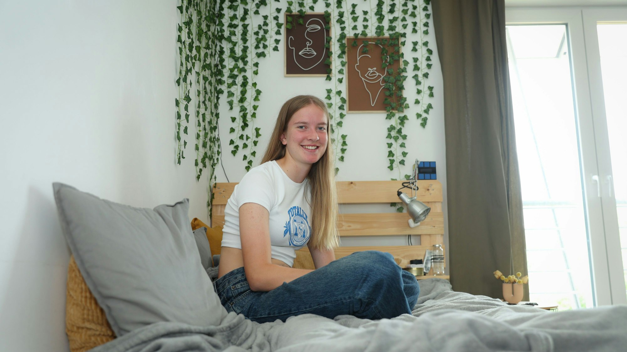 Rike Knipp (15) aus Nippes sitzt auf ihrem Bett in ihrem Zimmer.