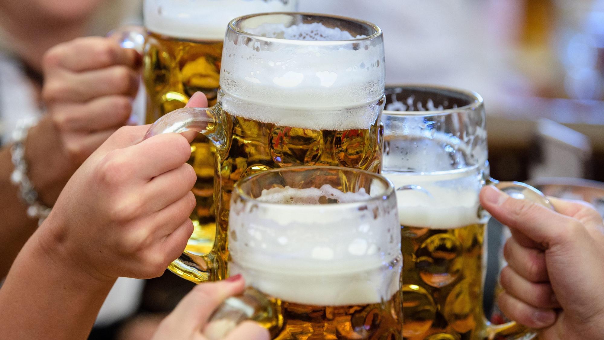 Besucherinnen prosten sich beim Auftakt zum Oktoberfest im Paulaner-Festzelt mit ihrer ersten Maß Bier zu.