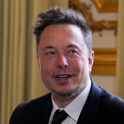 Es ist Elon Musk zu sehen, der leicht lächelnd an der Kamera vorbeischaut.