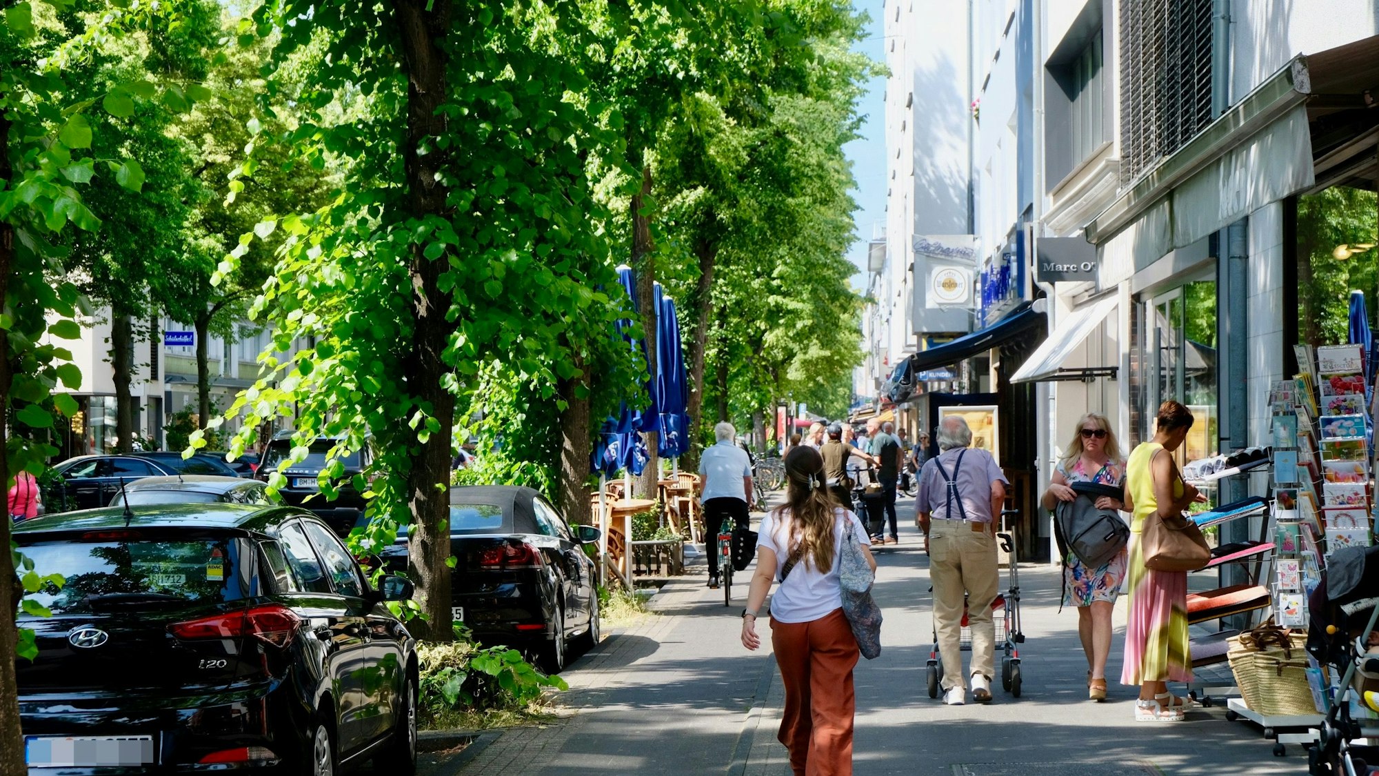 Eine Straße mit parkenden Autos, Rad- und Gehweg ist zu sehen.