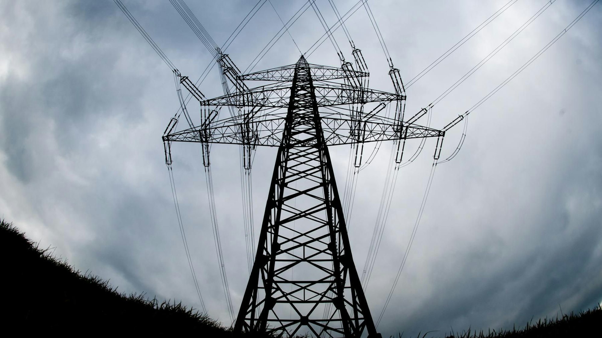 Ein Strommast steht auf einem Feld.