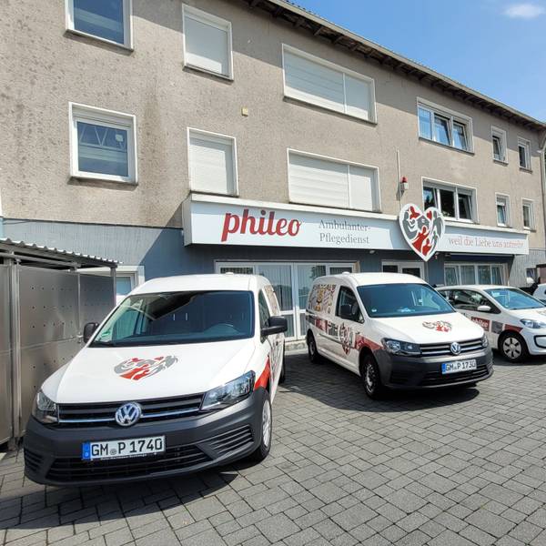 Mehrere VW-Caddys eines Pflegedienstes stehen auf einem Hof nebeneinander.