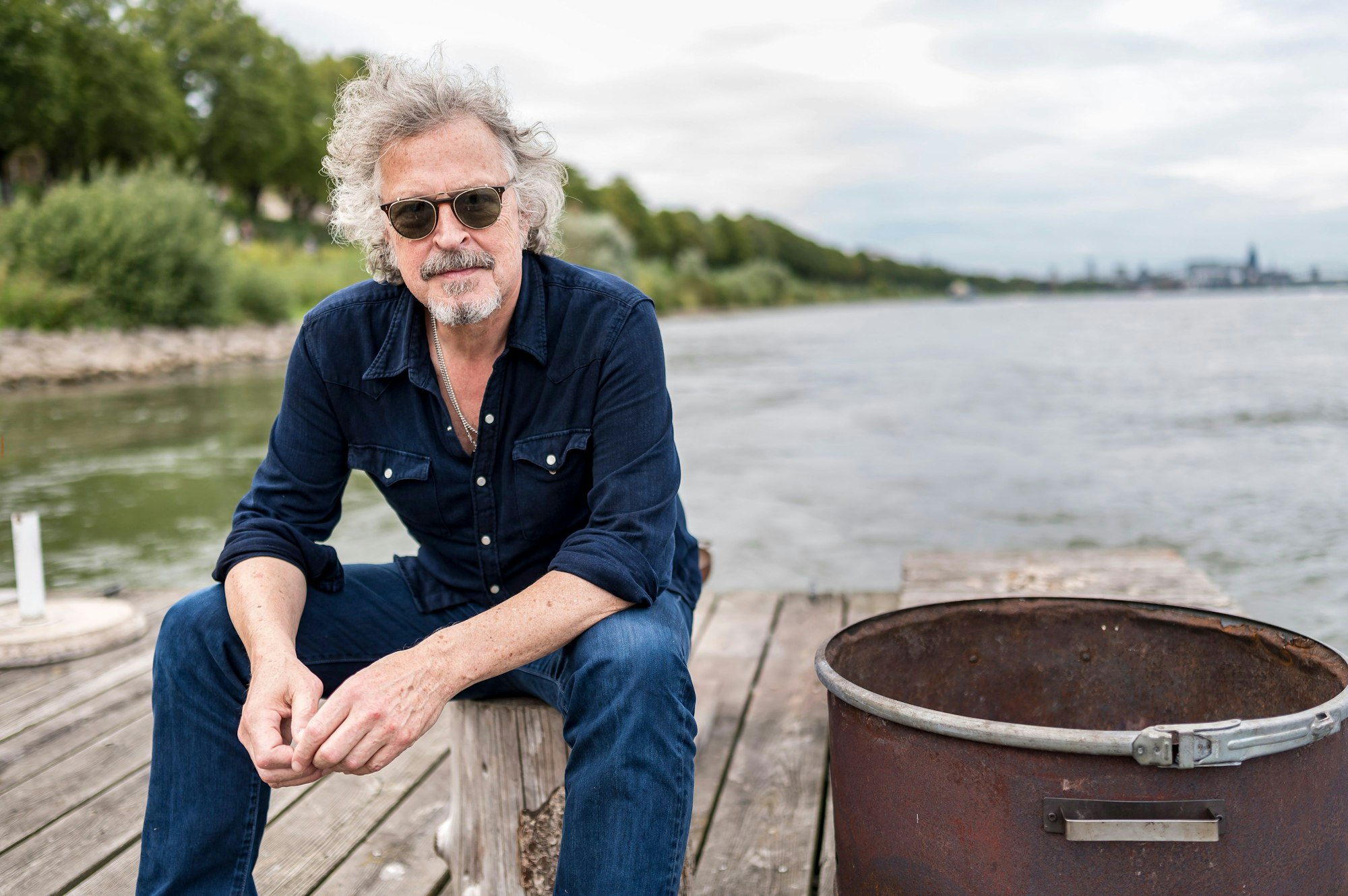 Wolfgang Niedecken sitzt am Rhein.