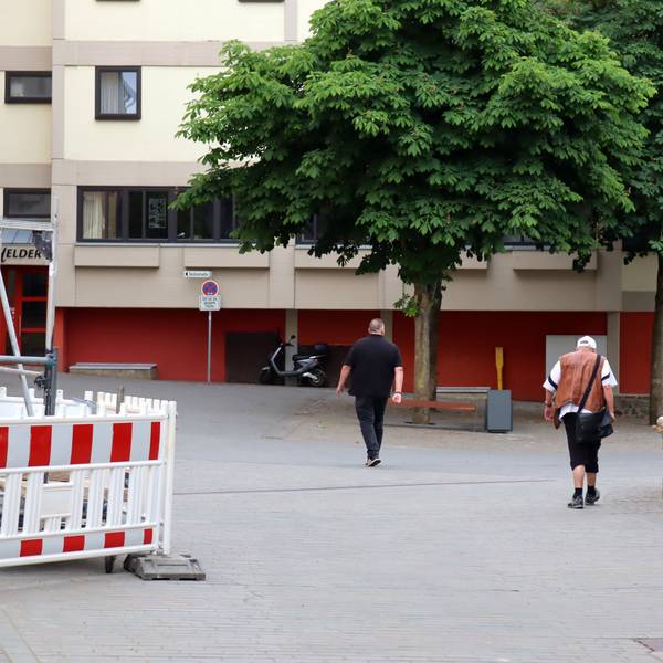 Zwei Passanten auf dem Markt vor dem St.-Michael-Gymnasium.