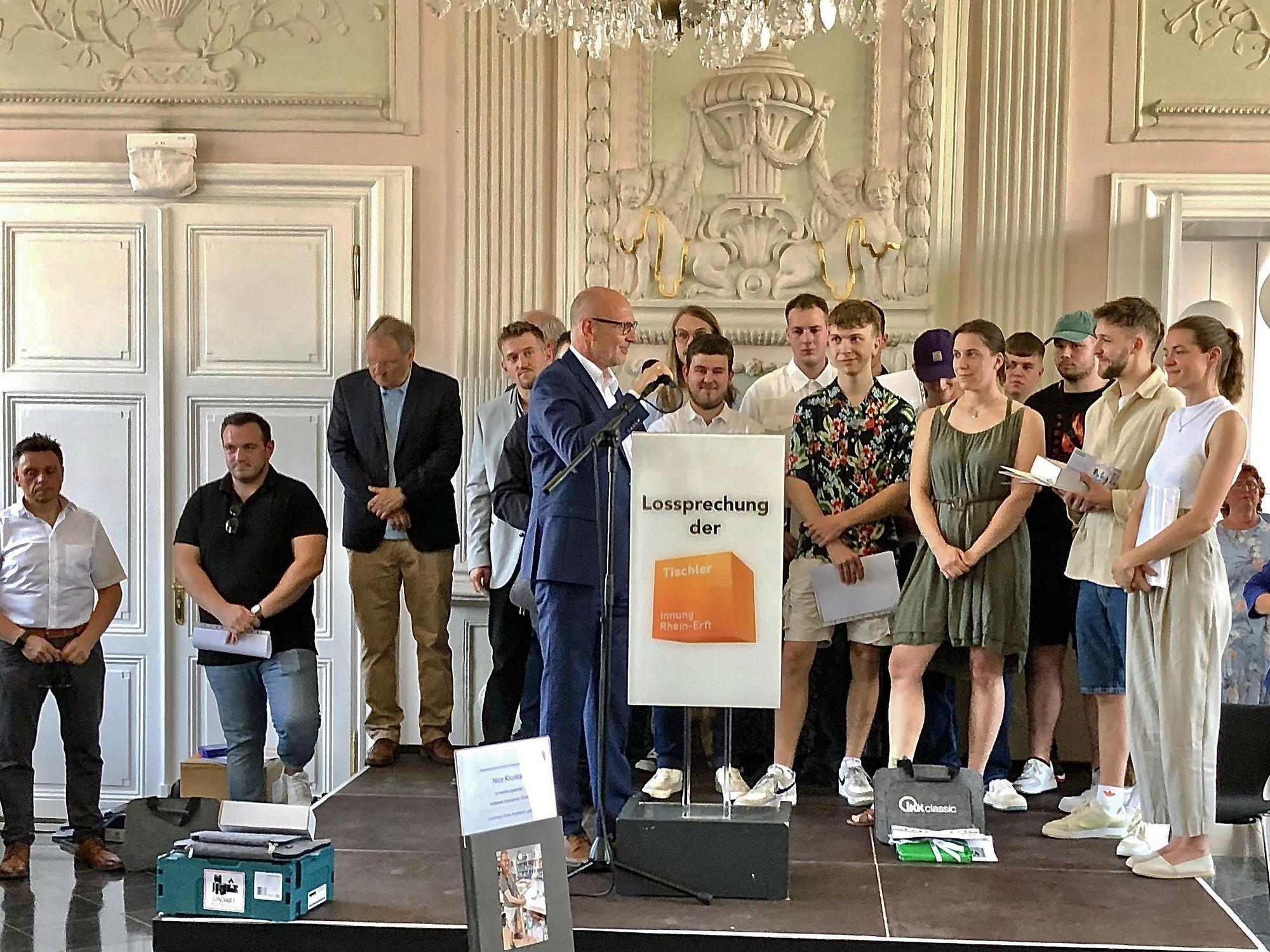 Das Foto zeigt 13 der 14 Gesellinnen und Gesellen auf einer Bühne.
