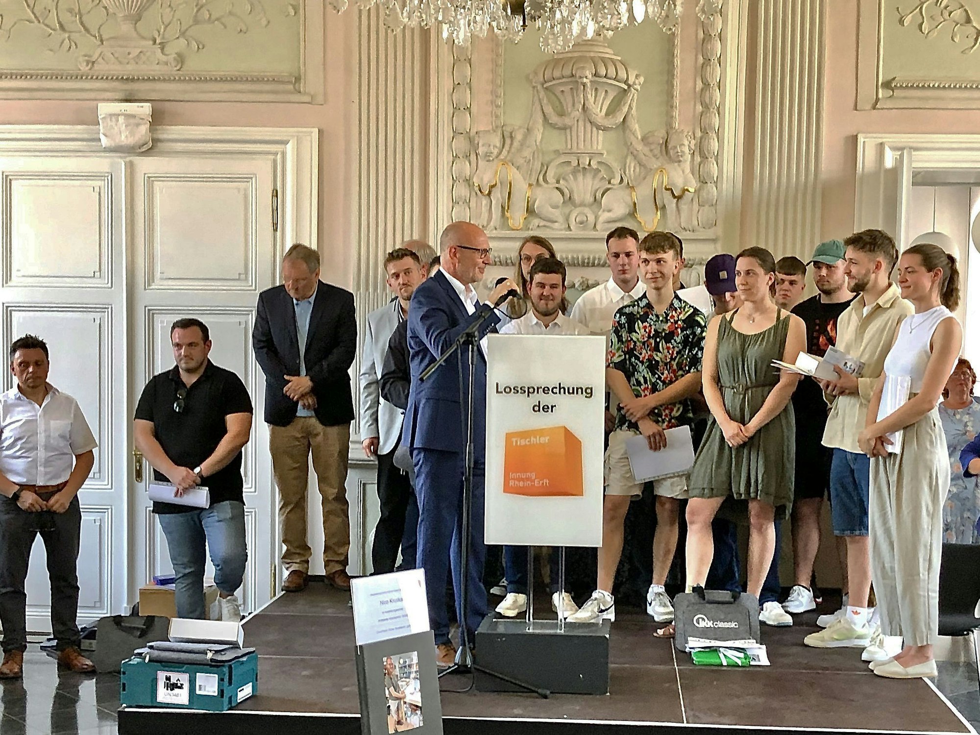 Das Foto zeigt 13 der 14 Gesellinnen und Gesellen auf einer Bühne.