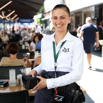 Eine Köbine hält in Köln eine Geldbörse in der Hand.