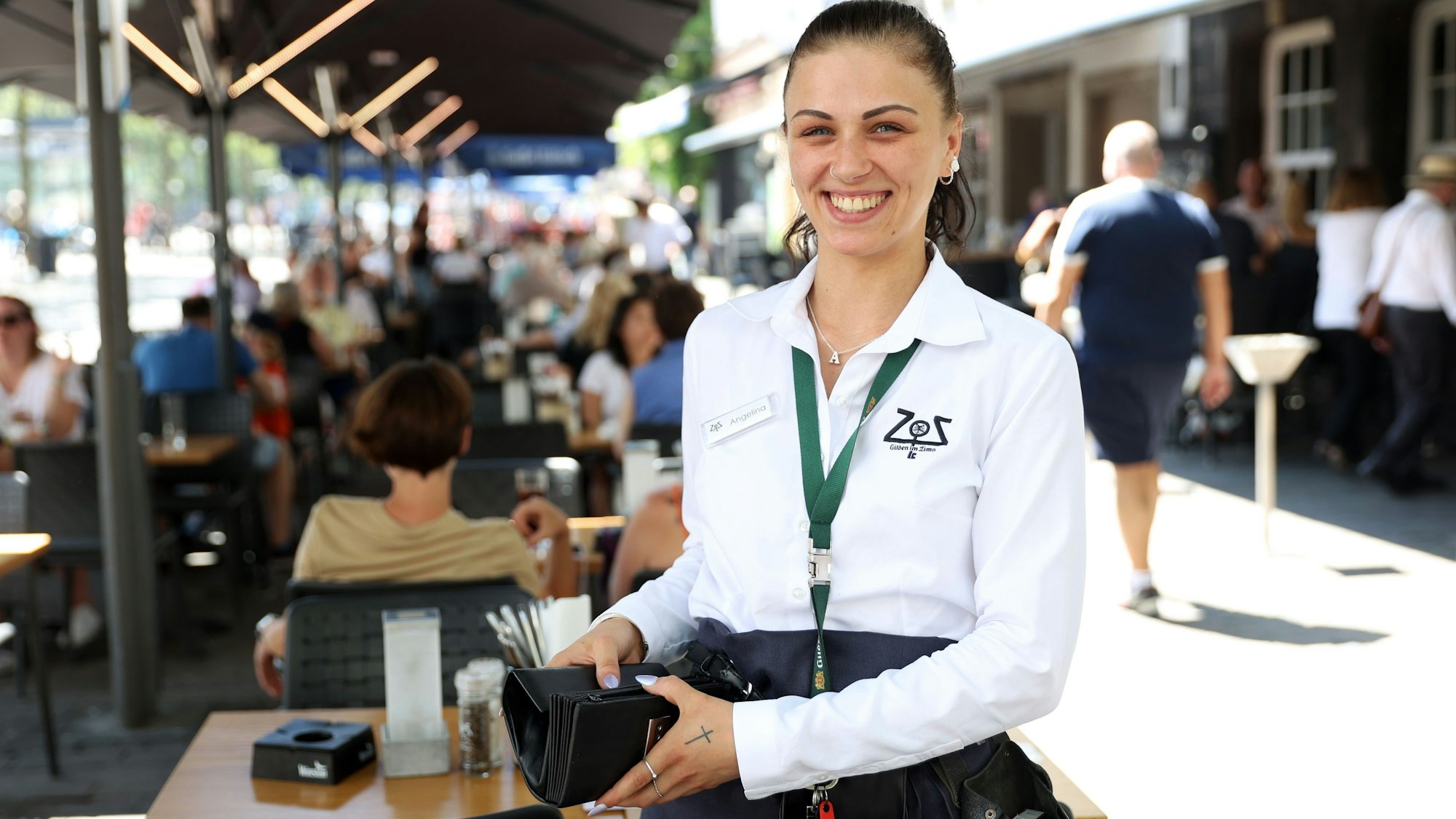 Eine Köbine hält in Köln eine Geldbörse in der Hand.