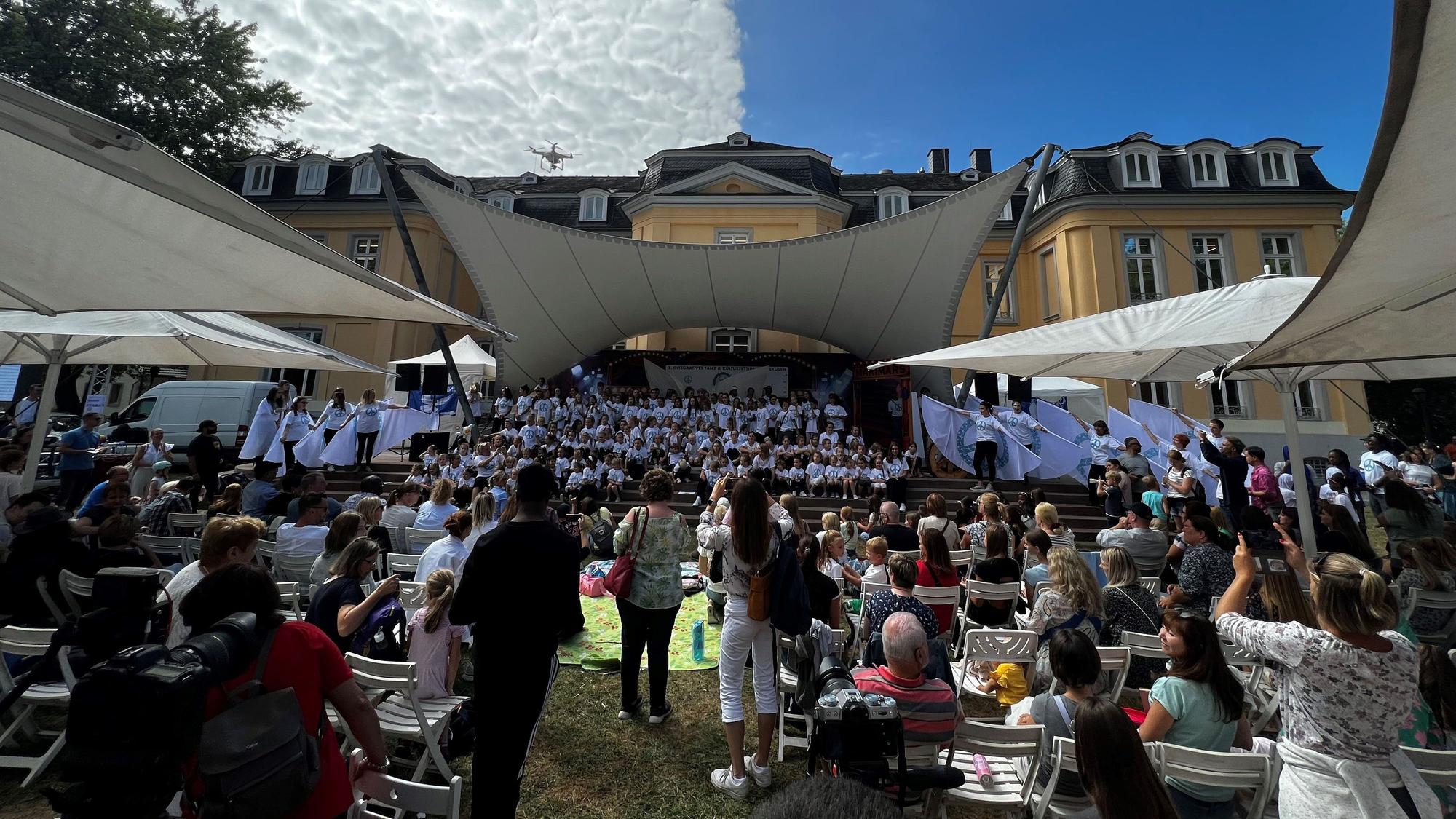 Viele Menschen vor und auf der Bühne im Schlosspark.