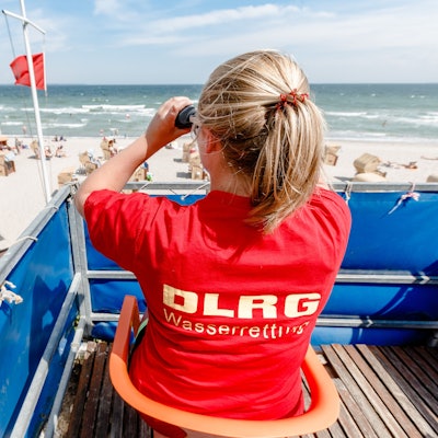 Eine Rettungsschwimmerin überwacht den Timmendorfer Strand. In der Nacht zu Sonntag wurde ein 17-Jähriger vermisst, es kam zu einer großen Suchaktion am Ostseestrand. (Symbolbild)