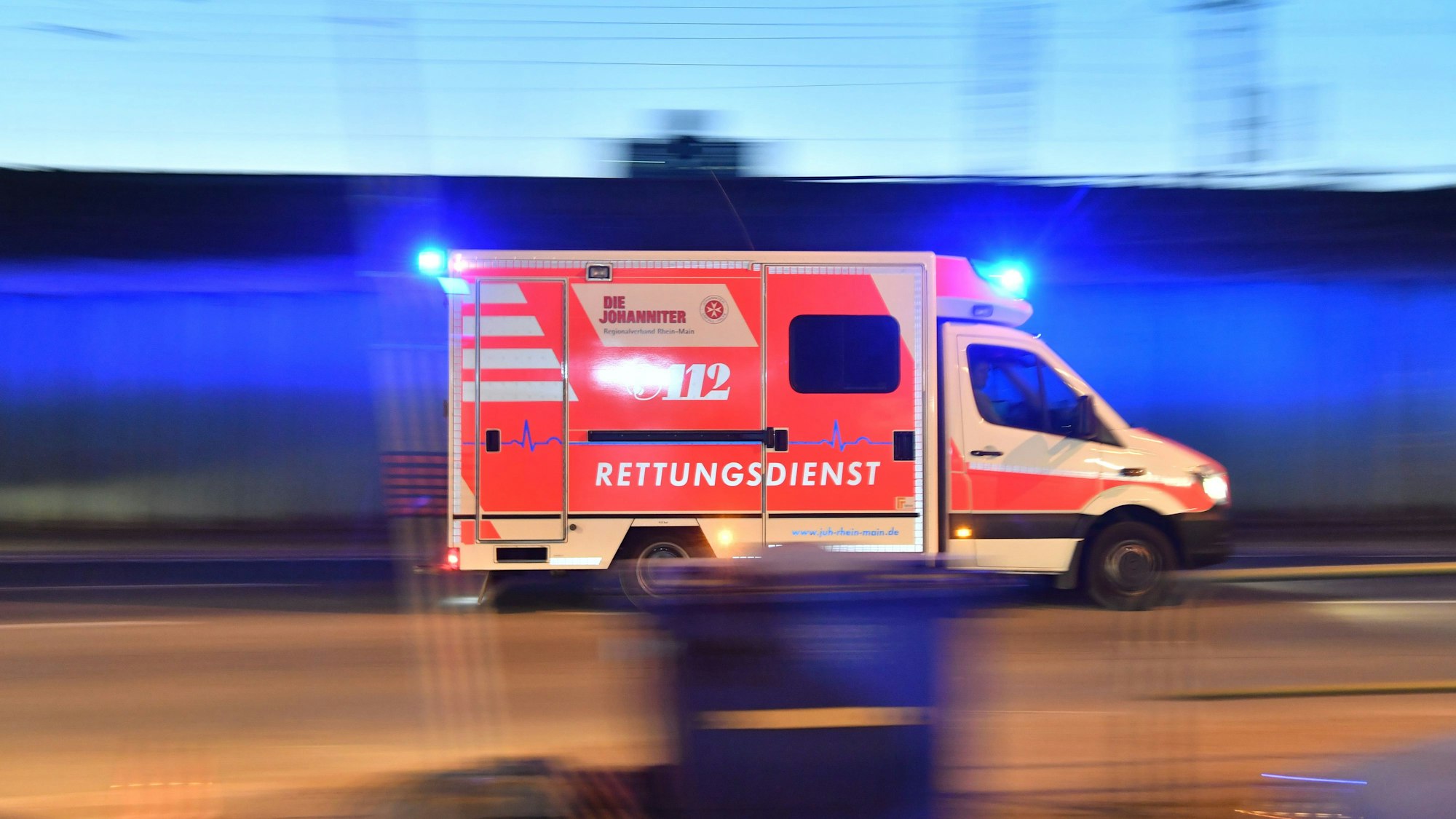 Ein Rettungswagen ist mit eingeschaltetem Blaulicht im Einsatz.
