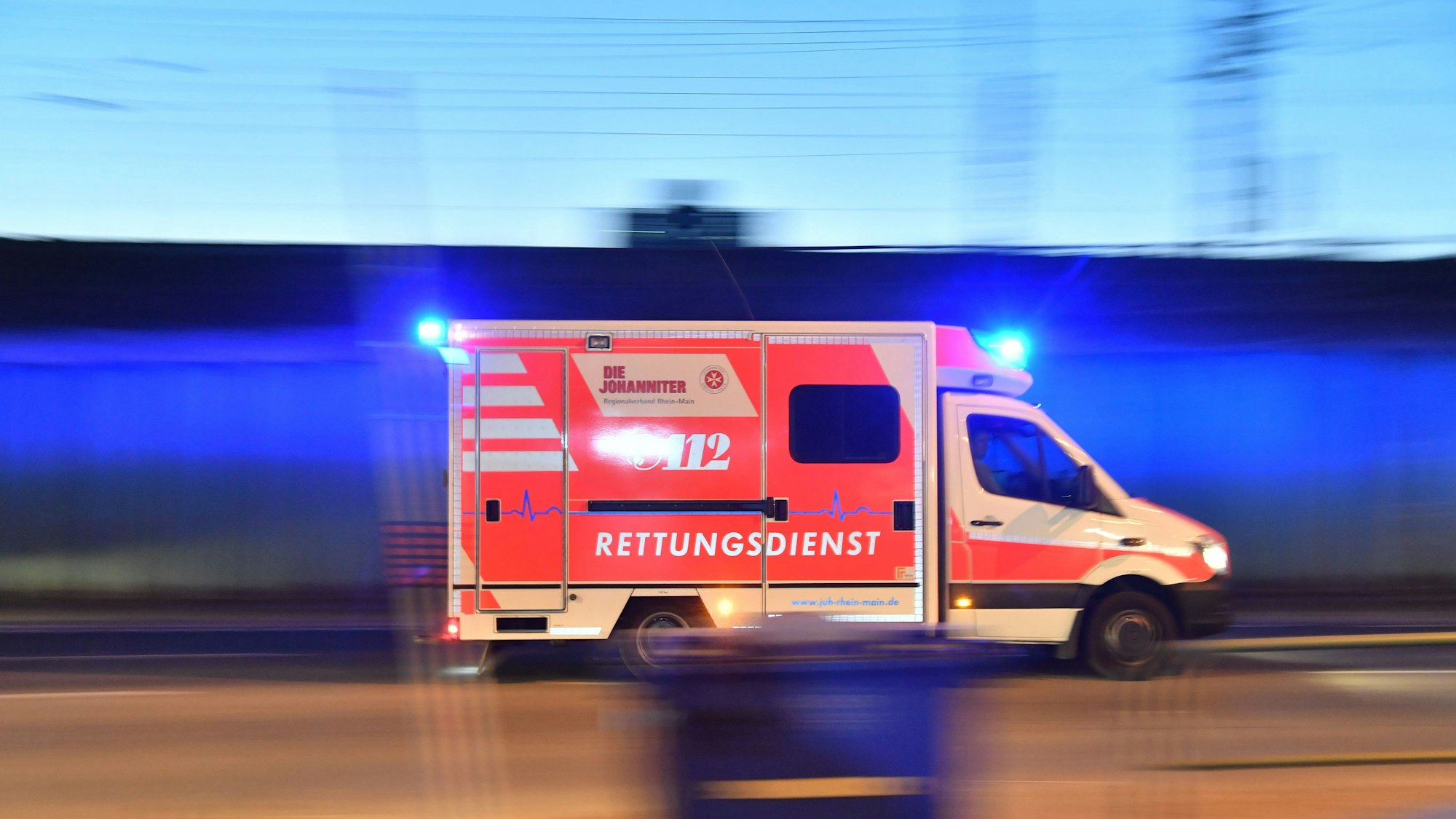 Ein Rettungswagen ist mit eingeschaltetem Blaulicht im Einsatz.