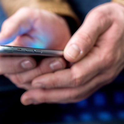 Mann hält Smartphone in den Händen.