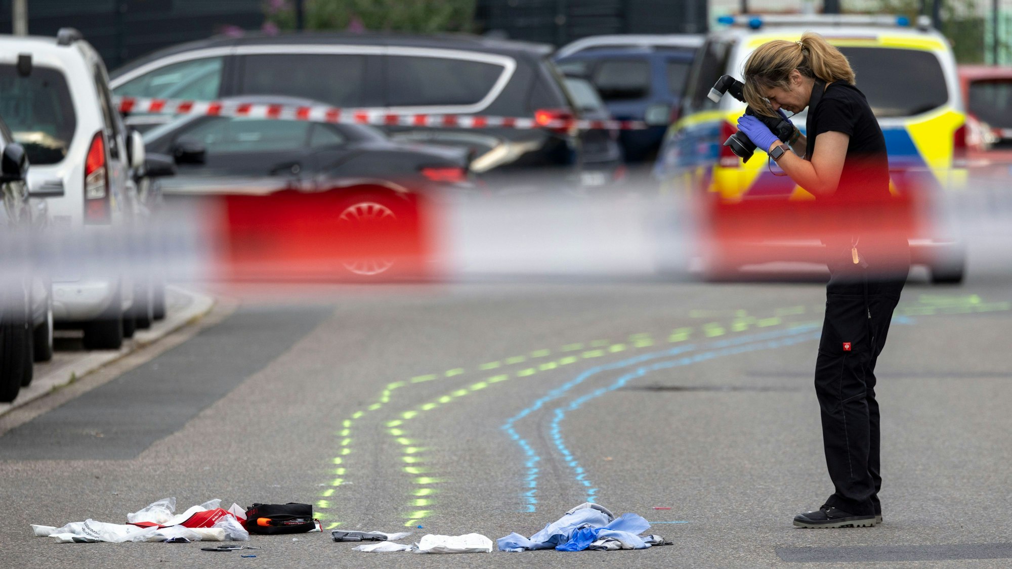 Essen: Eine Polizeibeamtin fotografiert die Kleidung und Spuren auf der Straße.
